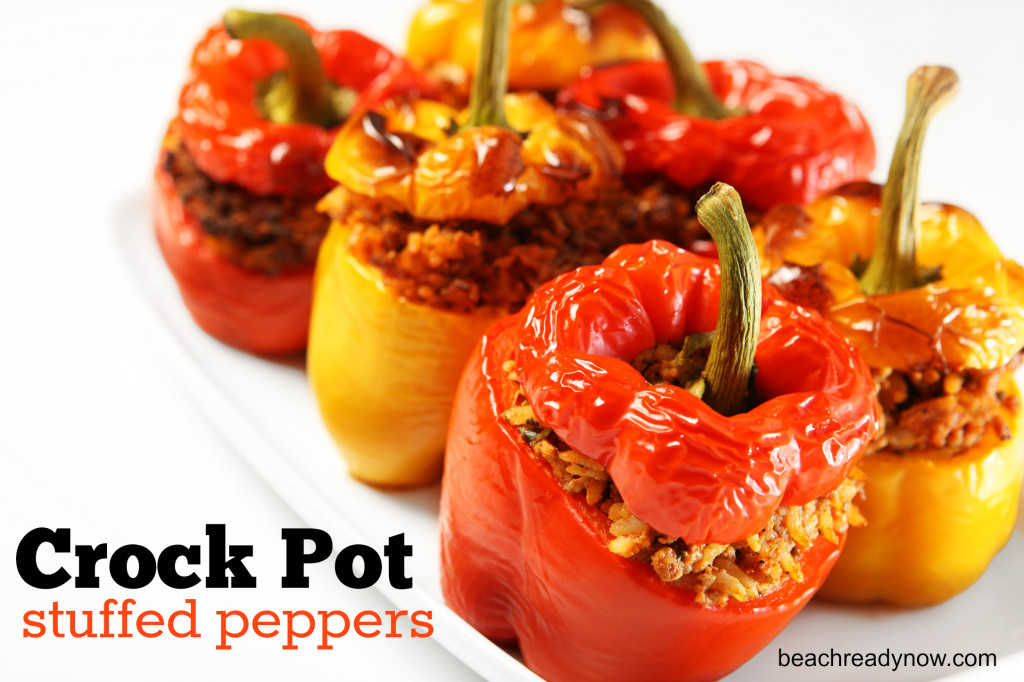 A picture of red and yellow stuffed peppers baked and served on a white plate